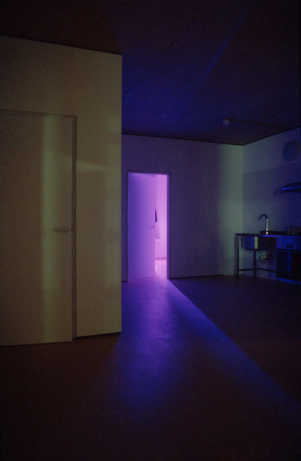 Purple light shines through an open door.